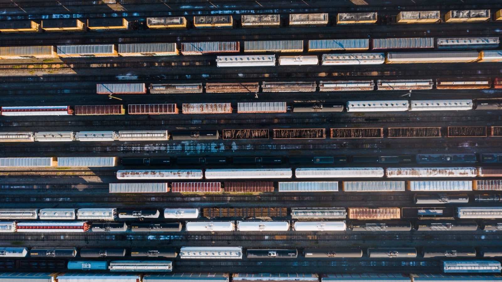 Overhead view of freight cars standing on the many parallel tracks of a classification yard at sunrise
